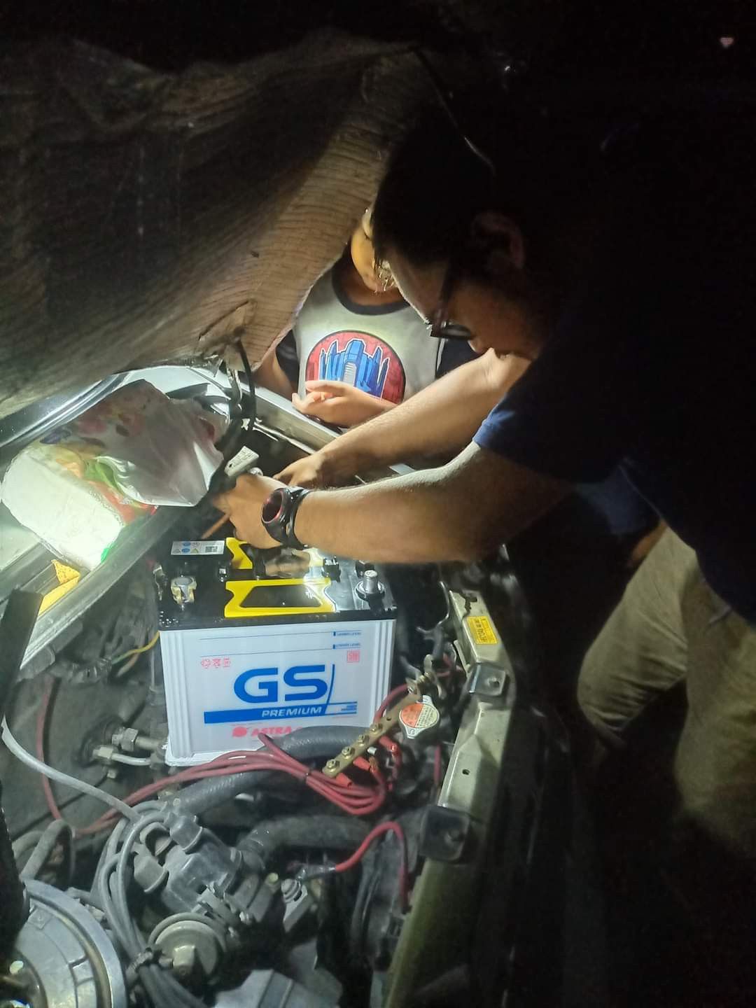 Montir mengganti aki mobil
