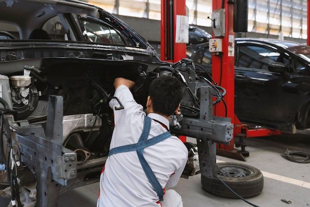 Montir sedang memperbaiki mesin mobil