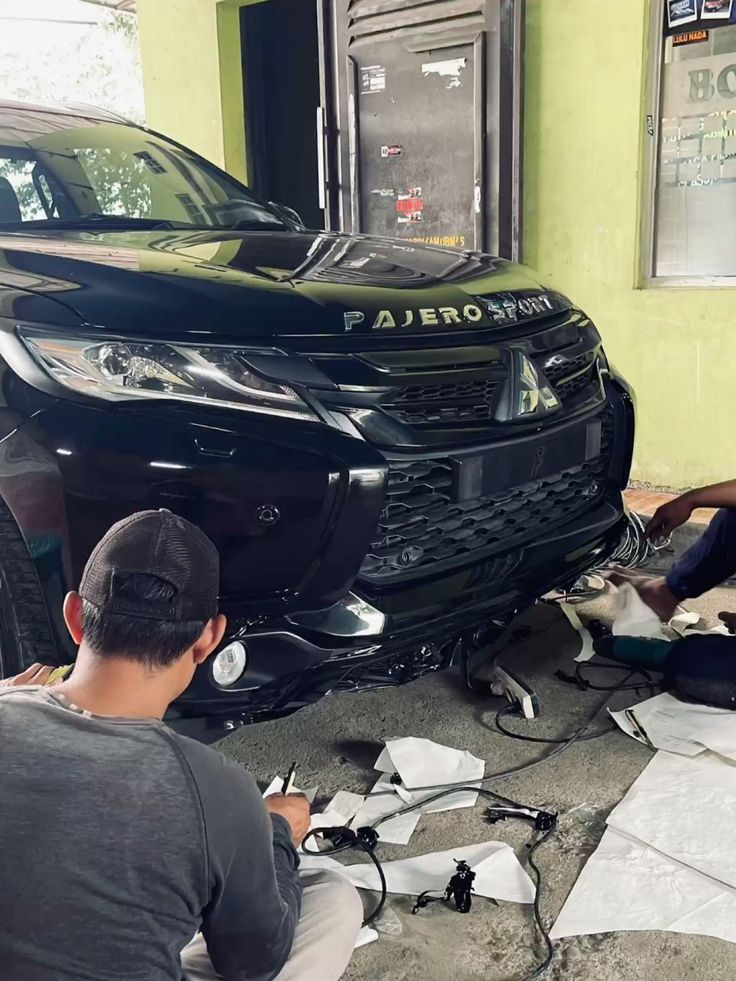 Montir memperbaiki mesin mobil di lokasi